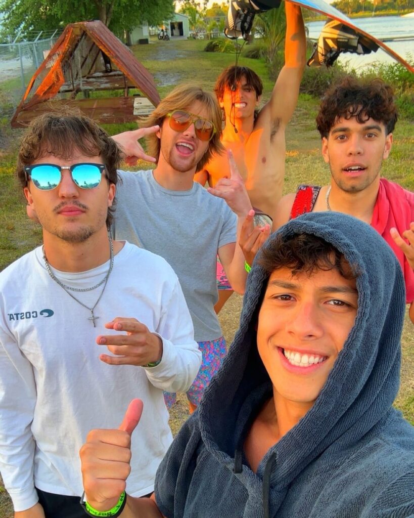 Kyle Abellar posing outdoors with palm trees in background